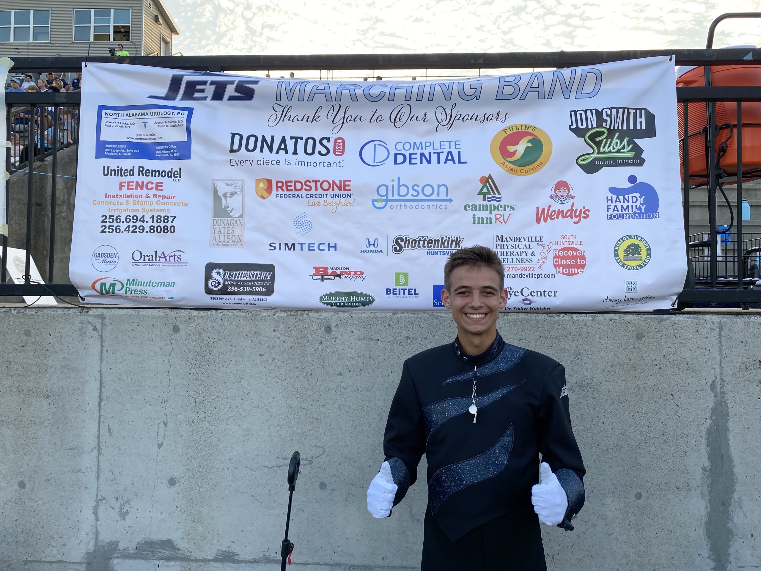 Drum Major with Sponsors banner